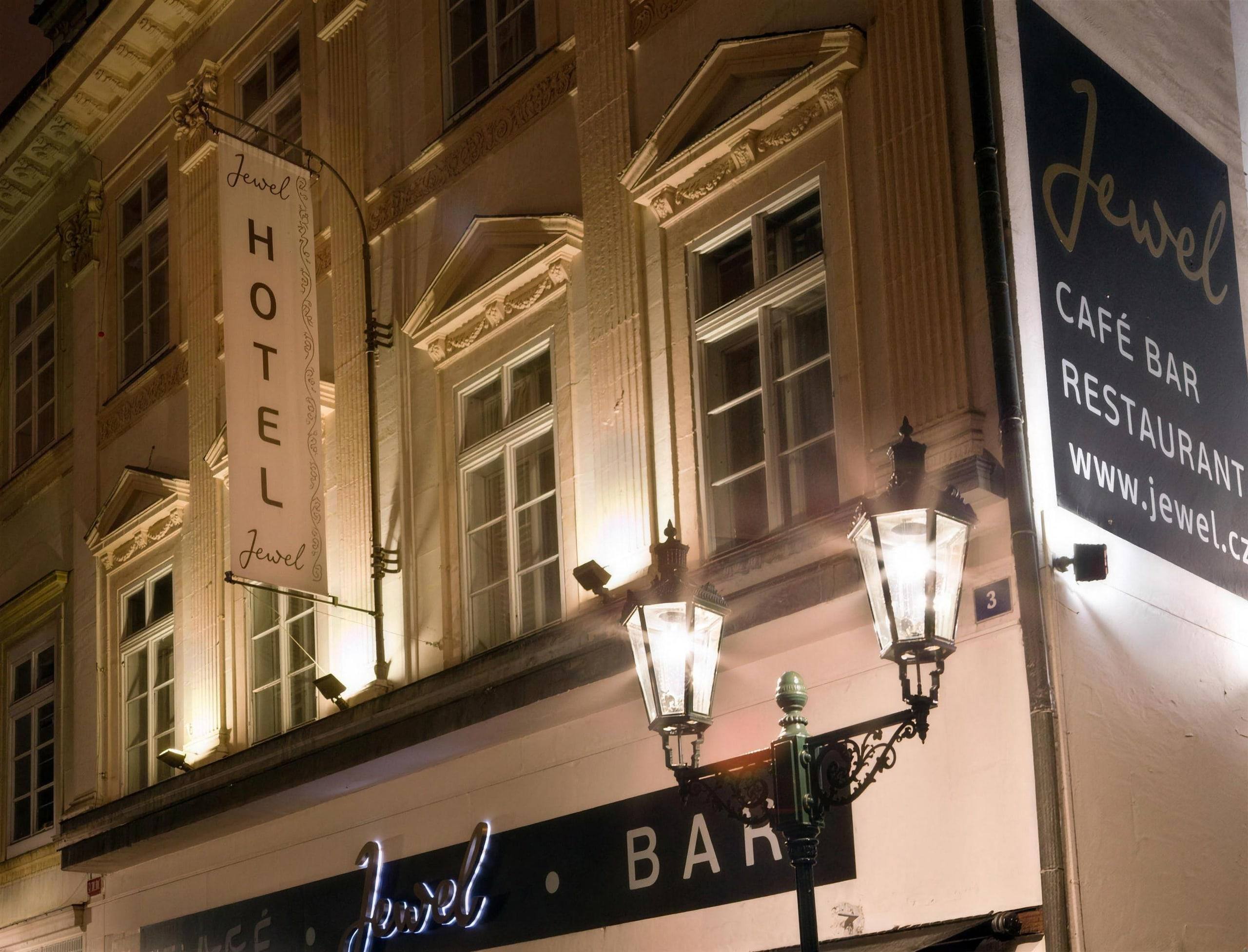 Night-time façade of Design Hotel Jewel on Rytířská Street with its HOTEL banner and historic lanterns