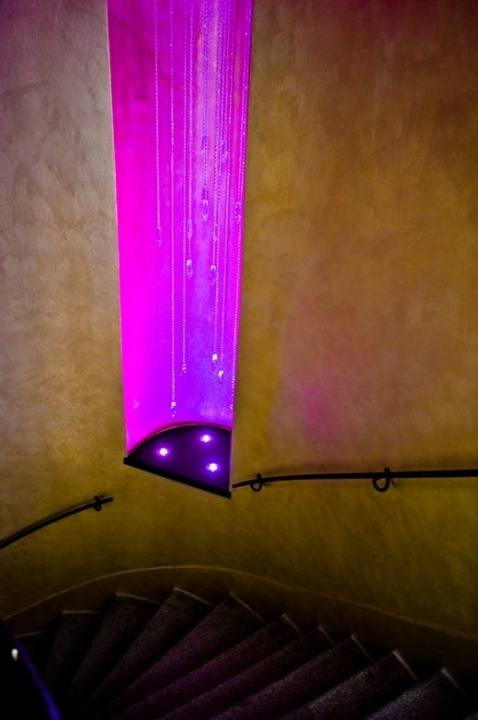 The hotel's spiral staircase with a column of crystal drops lit in magenta