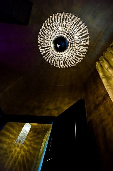 Round crystal chandelier on a dark ceiling, seen from below