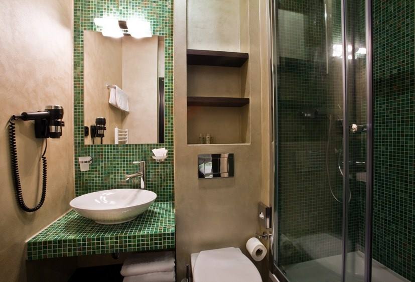 Emerald room bathroom with green mosaic tiles, vessel basin and shower
