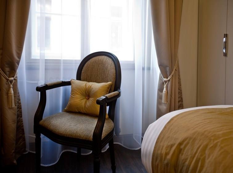 Armchair with a gold cushion by the curtained window in the Amber room