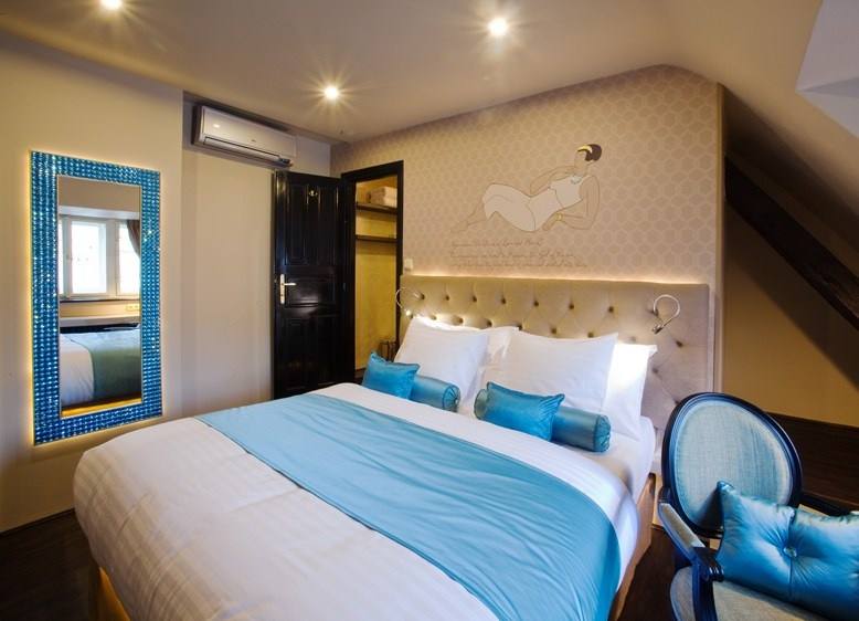 Aquamarine room with double bed, turquoise-crystal mirror and medallion armchair