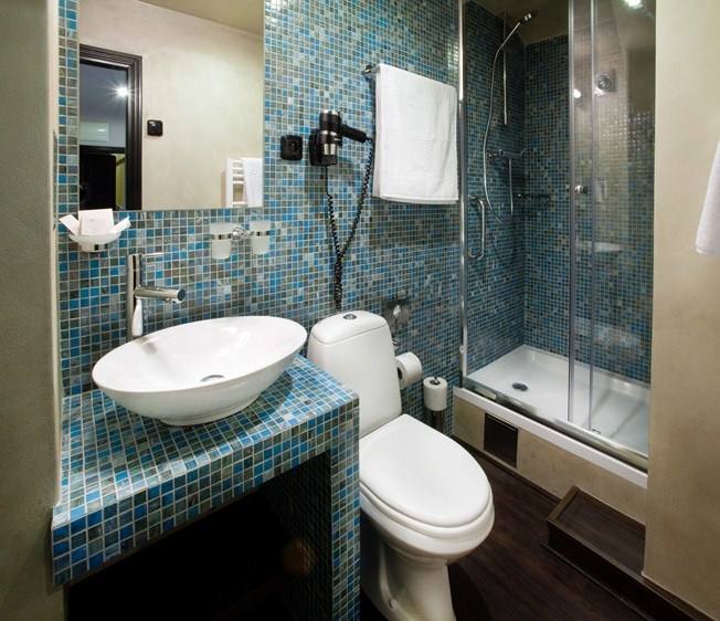 Aquamarine room bathroom with blue mosaic tiles, vessel basin and shower