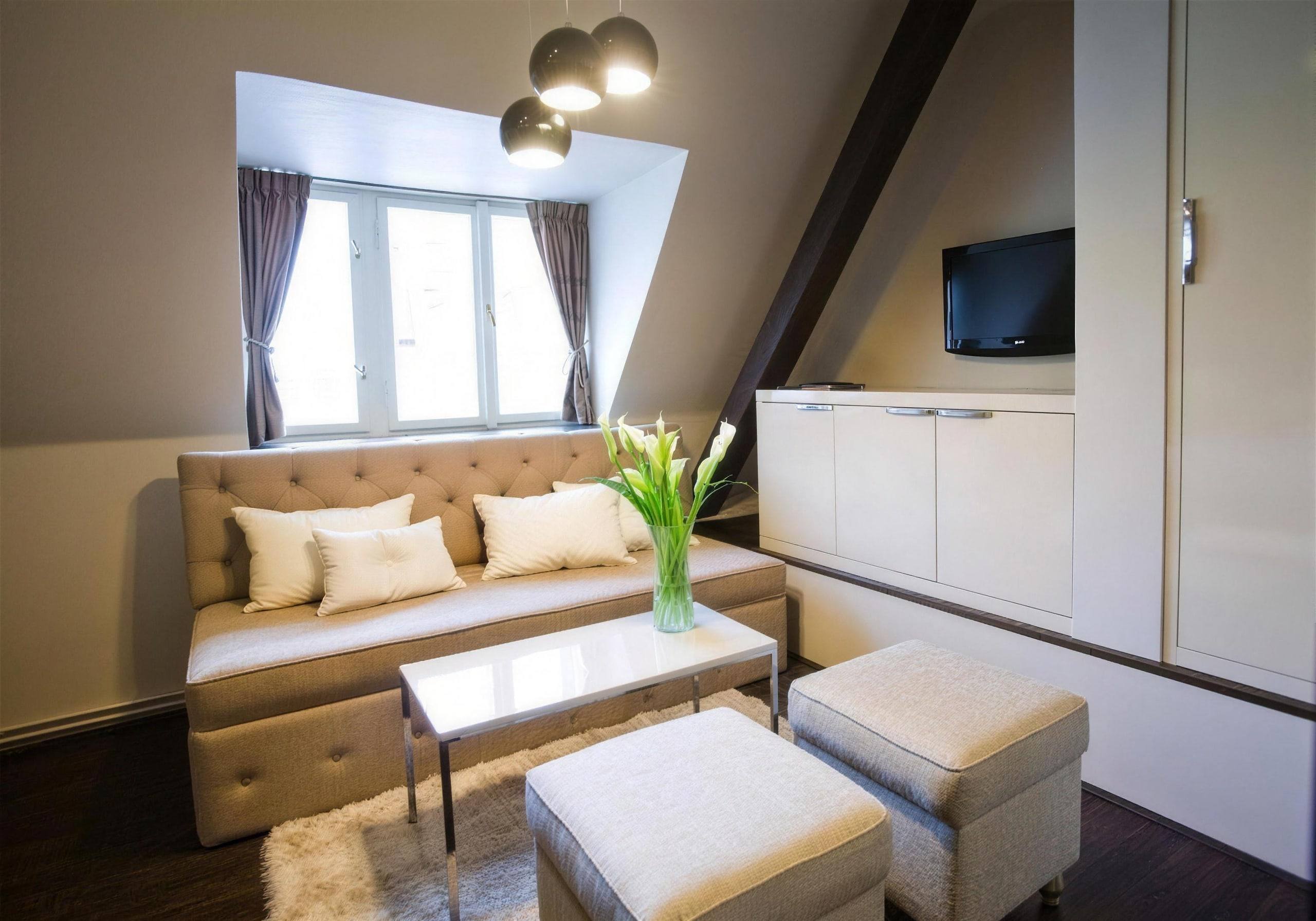 Sitting area in the Perla room with sofa, calla lilies and dormer window