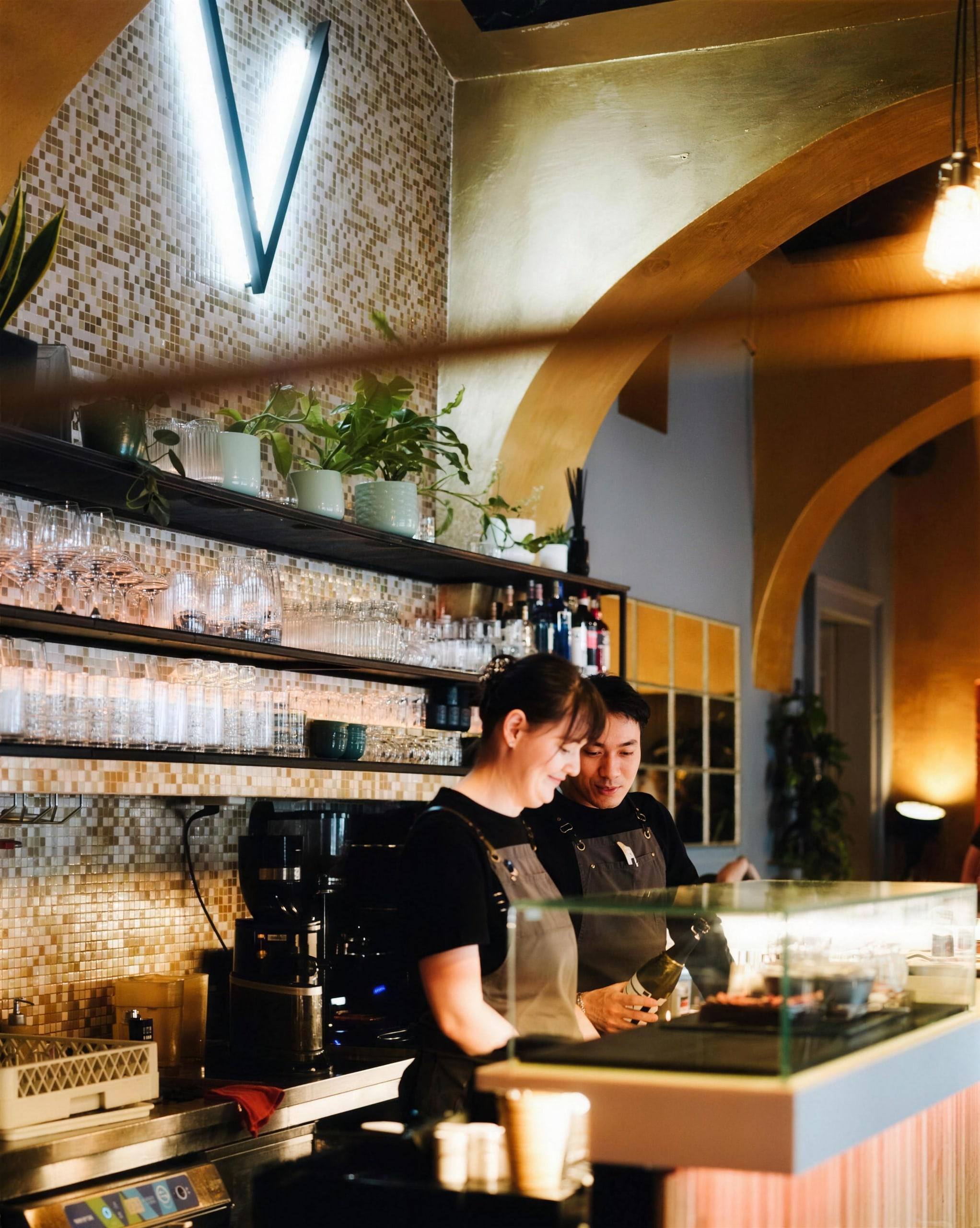 Jewel Café bar with mosaic wall, glass shelves and baristas behind the counter